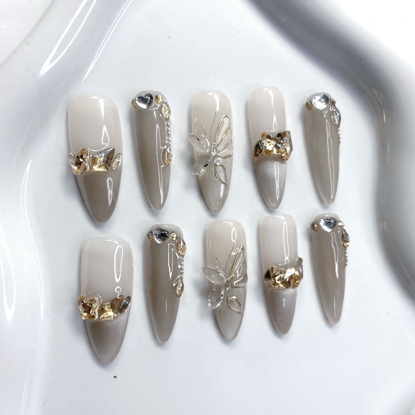 Purely handmade butterfly-shaped nail tips with dense cat's eye patterns, high-end nail art, gradient color change, and light luxury studded with rhinestones.